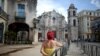 Una mujer espera junto a una cerca metálica, luego que se anunciara la muerte del cardenal Jaime Ortega, el viernes 26 de julio de 2019 en La Habana. REUTERS/Fernando Medina.