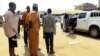 Oficiales de seguridad y civiles junto al auto donde secuestraron a los médicos cubanos en Mandera Kenia.