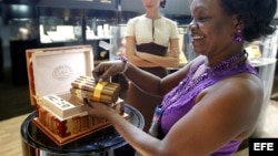 Una mujer muestra de mazo de tabacos en un local del 19 Festival del Habano, en La Habana.