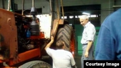 Técnicos bielorrusos inspeccionando los tractores de Cuba.