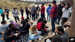 Los migrantes que buscan asilo descansan mientras esperan ser procesados después de cruzar la frontera el miércoles 5 de junio de 2024, en San Diego, California. Foto AP/Eugene García