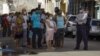 La policía controla la cola en tienda en dólares. (Adalberto ROQUE / AFP)
