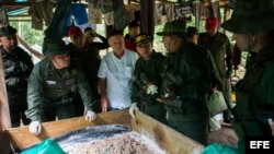 El ministro de defensa de Venezuela Vladimir Padrino López (i) y el gobernador del estado Zulia Francisco Arias Cárdenas (C) inspeccionan uno de los tres laboratorios de producción de cocaína desmantelados hoy, sábado 12 de diciembre de 2014.